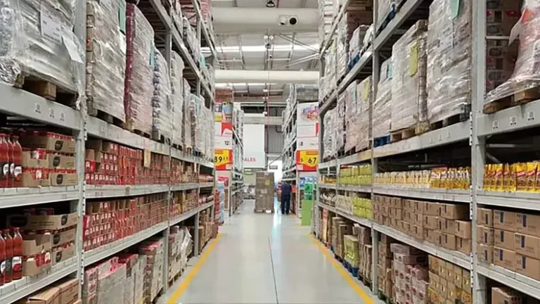 Depósito lleno de mercadería almacenada en estanterías, mostrando gran volumen de productos listos para distribución.
