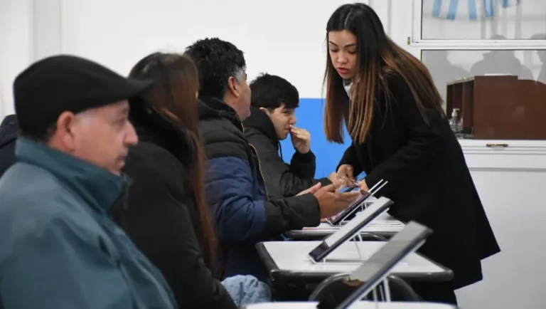 Personas realizando examen teórico digital para licencia de conducir frente a dispositivos electrónicos en Concordia