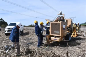 Trabajadores realizando la instalación de cableado de fibra óptica en el sistema eléctrico de Salto Grande