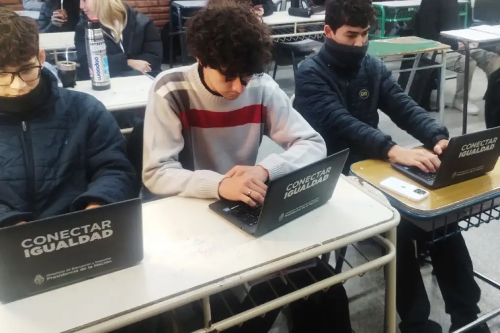 Estudiantes de una escuela técnica realizan pruebas y reparación de computadoras en un taller de informática.