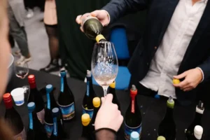 Copas de vino y botellas de bodegas exhibidas en una feria vitivinícola