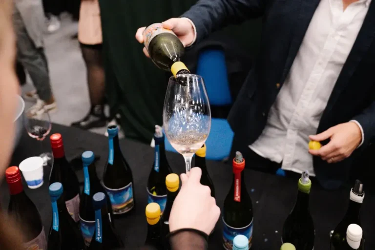 Copas de vino y botellas de bodegas exhibidas en una feria vitivinícola