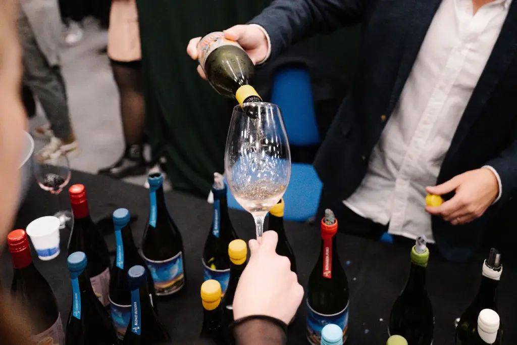 Copas de vino y botellas de bodegas exhibidas en una feria vitivinícola