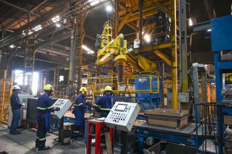 Obreros trabajan en una planta industrial durante una jornada de producción.